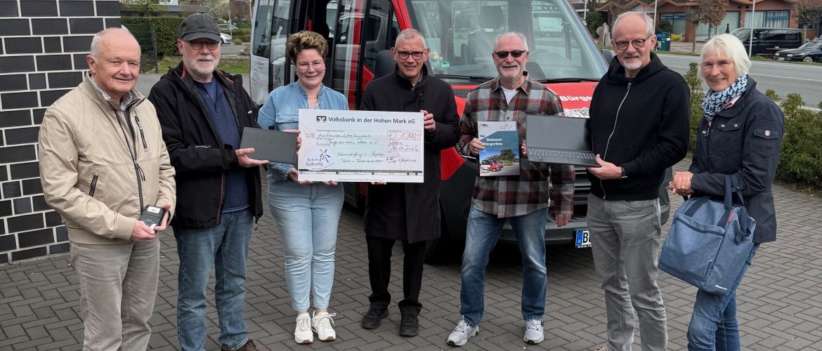 Thomas Hatwig vom Kuratorium der Reken-Stiftung und Ria Winking-Dülmer, Geschäftsführerin der Reken-Stiftung (Mitte) übergeben den Spendenscheck an den Vorsitzenden des Bürgerbusvereins, Josef Ewering sowie Herrn Stephan Emunds (von links). Gerald Middendorf (2. von rechts), Kassierer des Vereins, präsentiert den neuen Laptop. Neben ihm stehen die heutigen Fahrer*in.